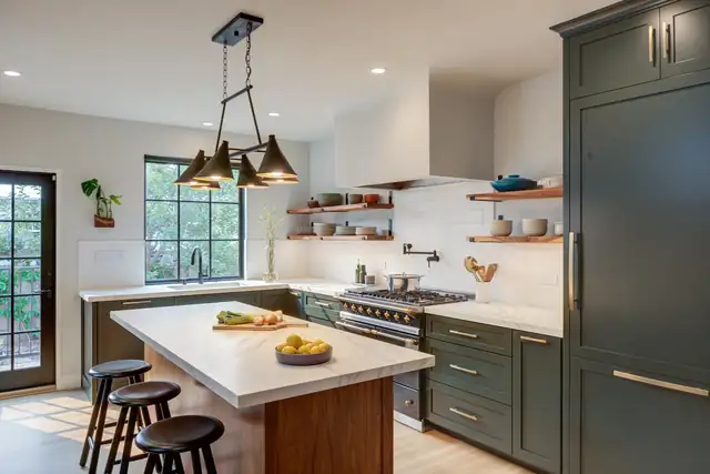Oakland kitchen with dark green cabinets, a wood-base island with stools, open shelves and black pendant lights