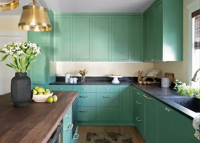 Haskell kitchen remodel in Berkeley with green shaker cabinets, black counters, a butcher block island and a brass pendant